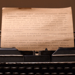 A imagem mostra uma máquina de escrever com um papel já com letras impressas.