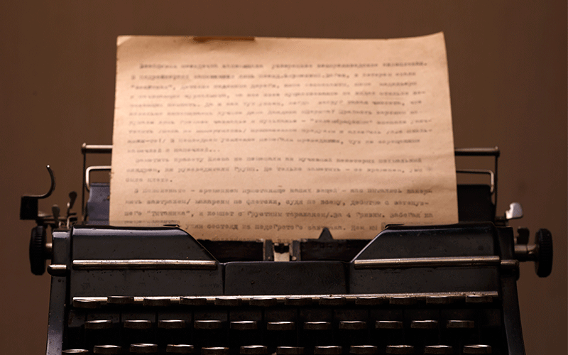 A imagem mostra uma máquina de escrever com um papel já com letras impressas.